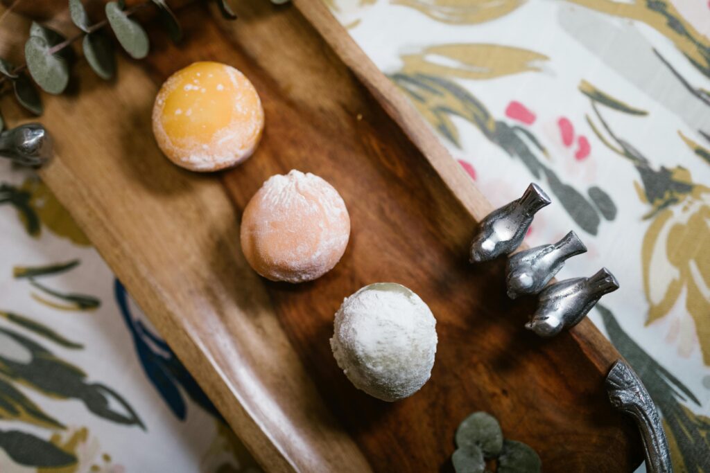 A vibrant assortment of mochi desserts elegantly presented on a wooden tray, perfect for food photography and culinary visuals.